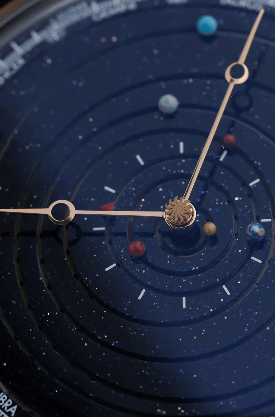 Planet orbits on a starry blue dial in close-up