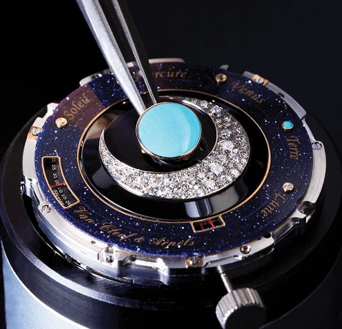 Diamond-set crescent being placed on a planetarium dial