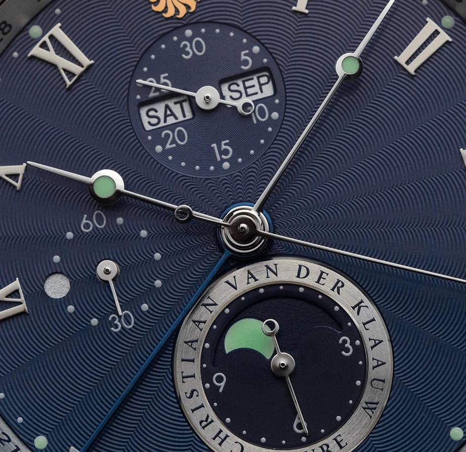 Blue dial with day and date windows and a moon phase in close-up