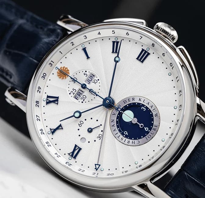 White chronograph dial with blue hands and a moon phase