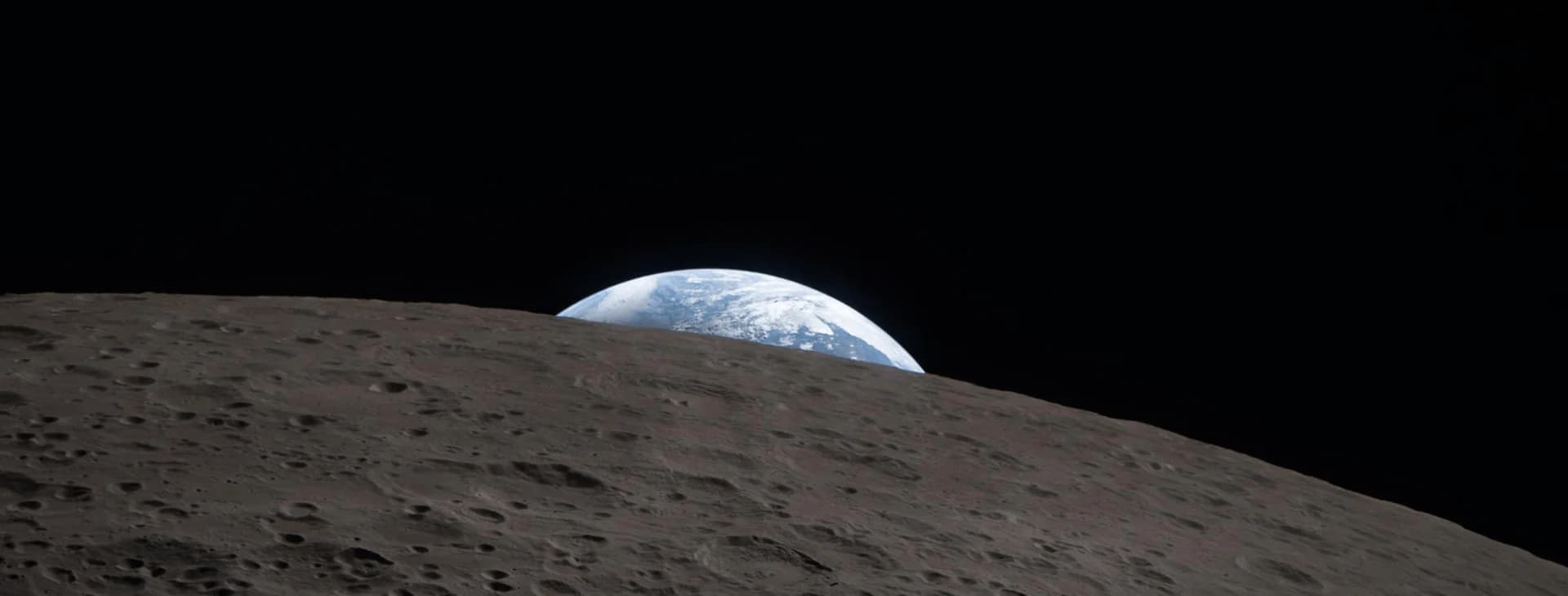 Earth rising over the lunar horizon