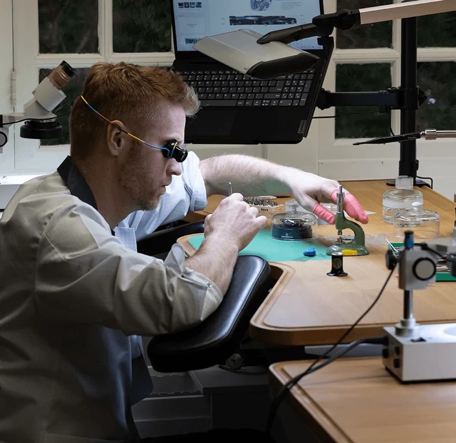 Watchmaker assembling a movement at the bench