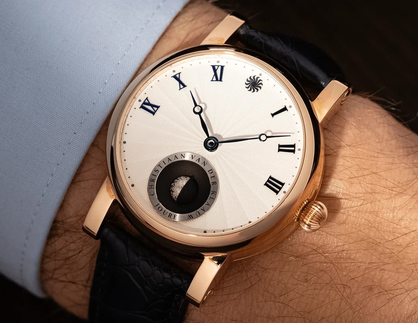 Watch with Roman numerals above the horizon and a moon display, on the wrist